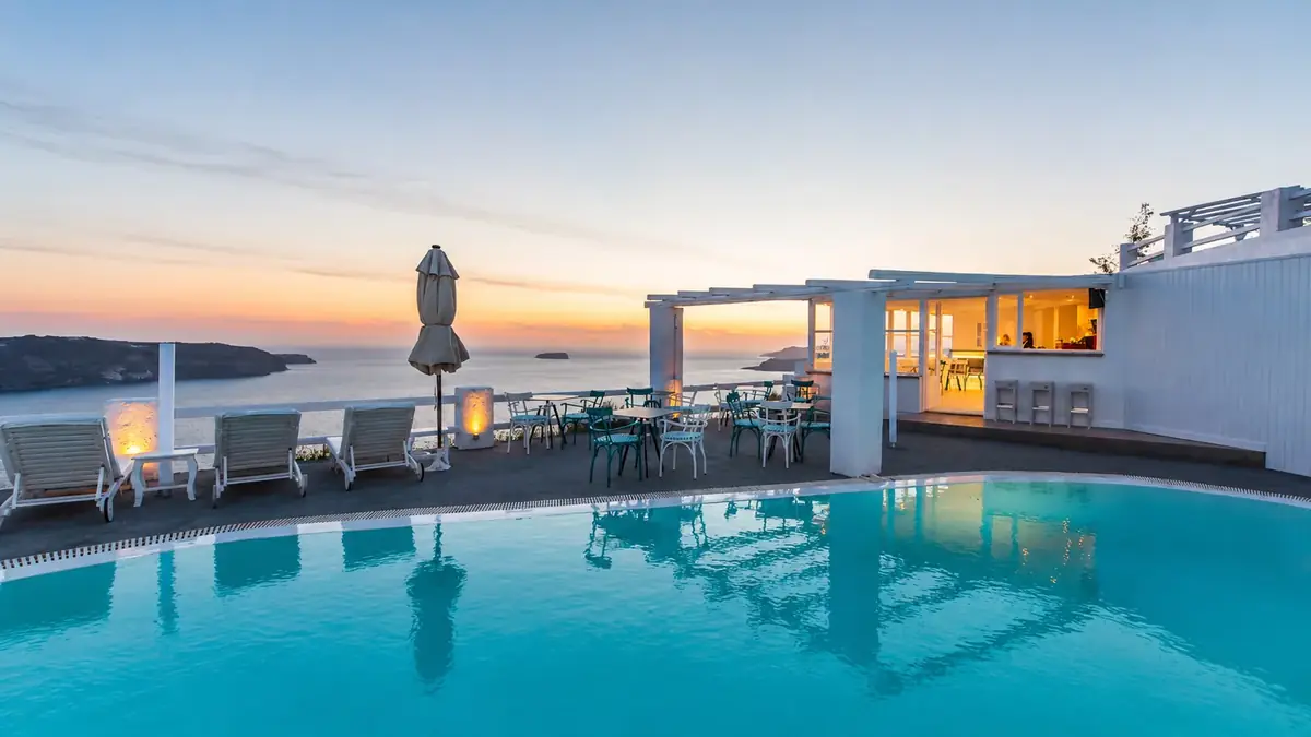 Whitewashed Cycladic exterior of Artemis Suites at sunset
