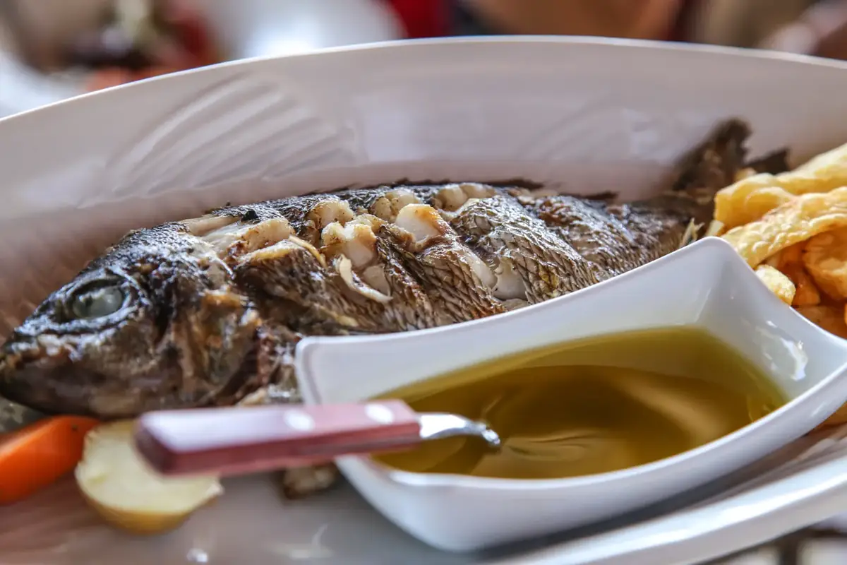 Whole grilled fish served with olive oil at Fish Tavern O Perivolos